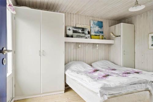 a small bedroom with a bed and a cabinet at LN76217-Hjorring-Hjaelmerenden-2 in Hjørring