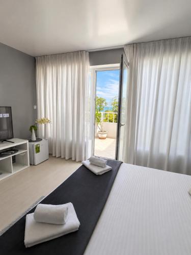 a bedroom with a large bed with two towels on it at Hotel Kamelia in Varna City