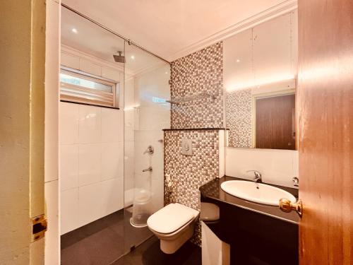 a bathroom with a toilet and a sink and a shower at Matha Residency in Kasauli