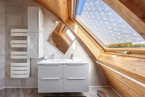 a bathroom with a sink and a window at Les Dômes Du Ponant in Plouguerneau