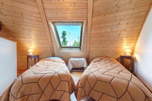 a bedroom with two beds in a wooden house at Les Dômes Du Ponant in Plouguerneau