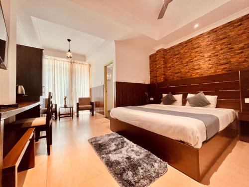a bedroom with a large bed and a brick wall at Matha Residency in Kasauli