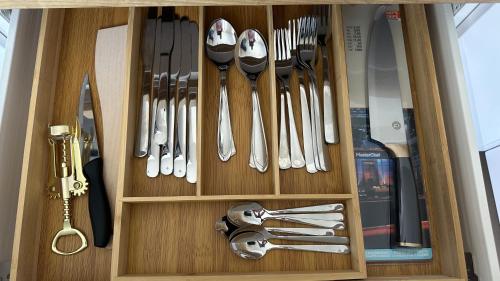 a wooden drawer filled with lots of utensils at Peaceful haven in Liepāja