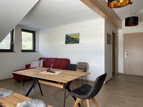 a living room with a wooden table and chairs at Apartment Turmfalke in Vogtsburg