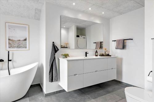 a white bathroom with a tub and a sink at LN1842-Hjorring-Lobet-5 in Hjørring