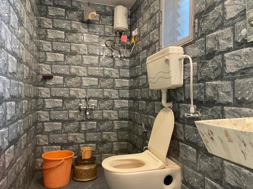 a bathroom with a toilet and a sink at Shree Krishna Sudha Resort in Alibaug