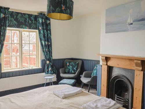 a bedroom with a bed and a fireplace at 5B Bridge Street in Lyme Regis