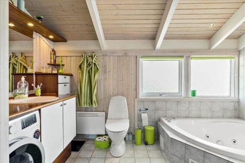 a bathroom with a tub and a toilet and a sink at LN674-Hjorring-Rodspaettevej-16 in Hjørring