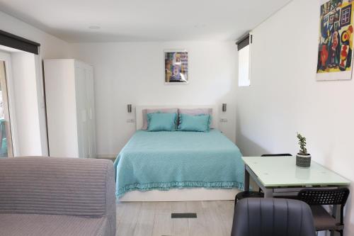 a bedroom with a bed with blue pillows and a table at Retiro Maria Idalina in Amarante
