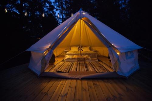 a tent with a bed on a wooden deck at Glamping - a living room overlooking the ocean in Hammarland