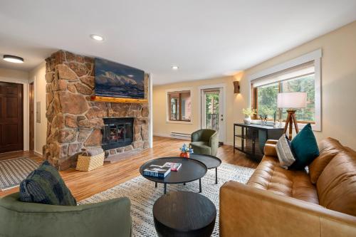 a living room with a couch and a stone fireplace at Winter Park Place #1 in Winter Park