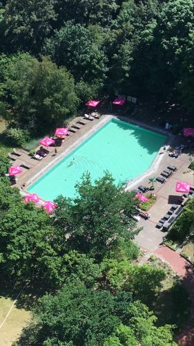 an overhead view of a swimming pool with chairs and umbrellas at Sunnyside 95 in Timmendorfer Strand