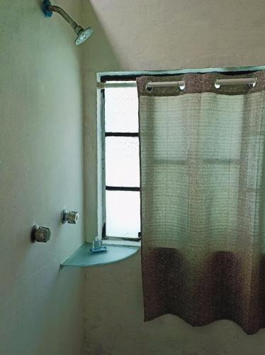 a shower curtain in a bathroom with a window at Hotel Antequera in Oaxaca City
