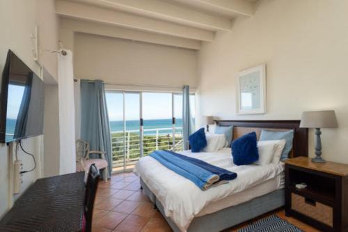 a bedroom with a bed with a view of the ocean at Bentley on the Beach in Umhlanga