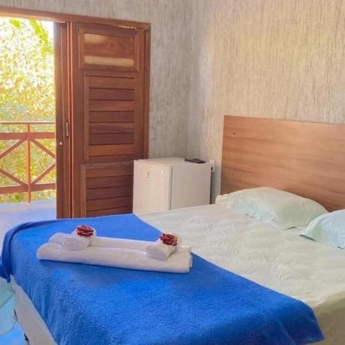 a room with a bed with a blue and white blanket at Orla Piaui in Luis Correia