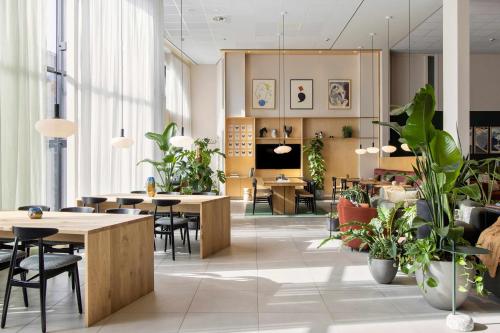 a restaurant with tables and chairs and potted plants at COVE Centrum in The Hague
