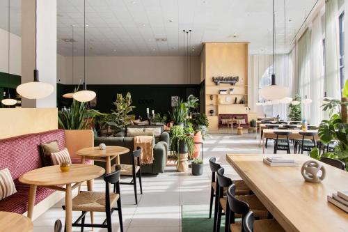 a restaurant with tables and chairs and potted plants at COVE Centrum in The Hague