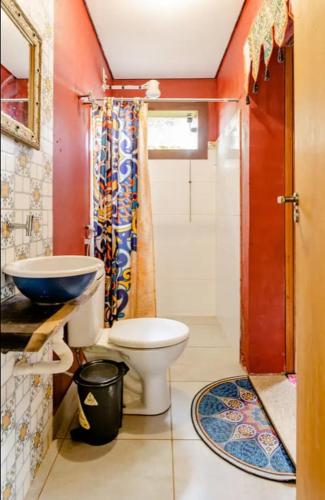 a bathroom with a toilet and a sink at Zíngara - Kombi Home in Brumadinho