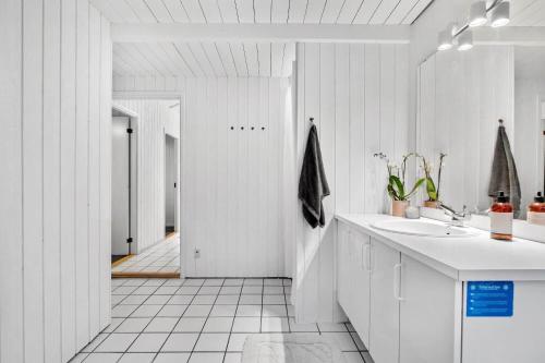 a white bathroom with a sink and a mirror at LN1791-Hjorring-Hongardsvej-1 in Hjørring