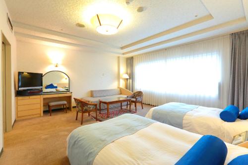 天草市にある望洋閣のベッド2台とテーブルがあるホテルの部屋