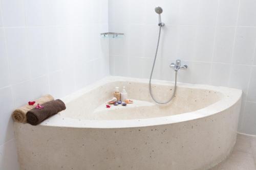 a bath tub with a shower in a bathroom at Villa Casablanco in Seminyak
