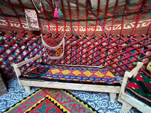 a bed with a colorful blanket on top of a room at Alima in Ottuk