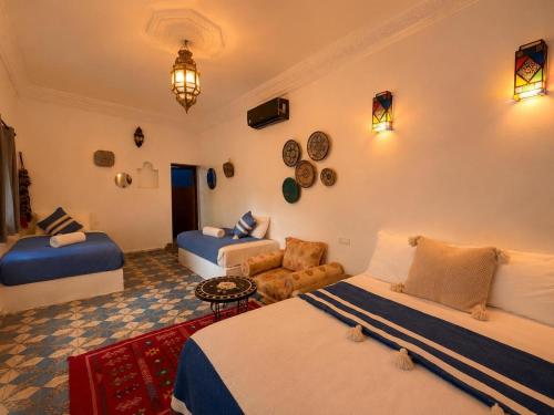 a bedroom with two beds and a living room at Riad Dar El Kaid in Fez