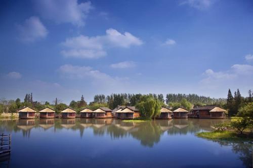 a row of wooden huts on a large lake at Dockside Boutique Hotel (In Xizha Scenic Area - ticket included) in Tongxiang