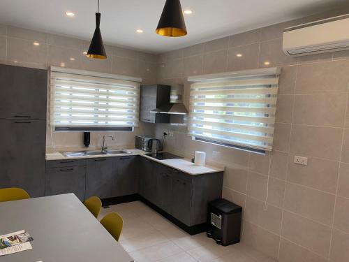 a kitchen with two windows and a table with chairs at Casa Bianca in Accra