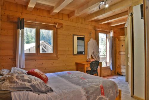 a bedroom with a bed in a log cabin at Chalet Le Plan du Rtia in Morzine