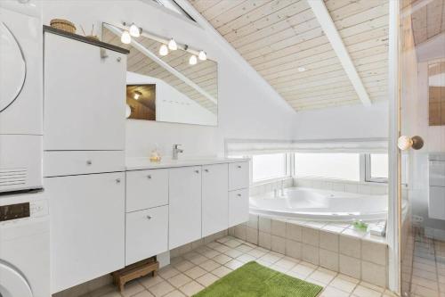 a white bathroom with a tub and a sink at LN1954-Hirtshals-Harestien-27 in Hirtshals