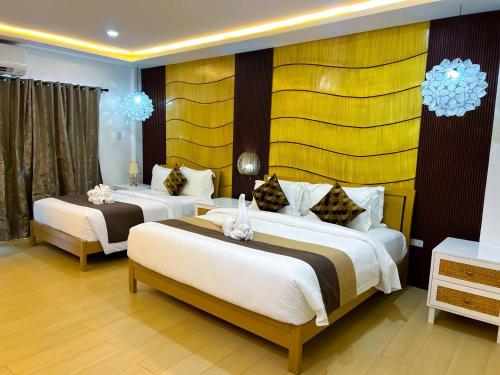 a hotel room with two beds in a room at Yuhum Boracay Suites in Boracay