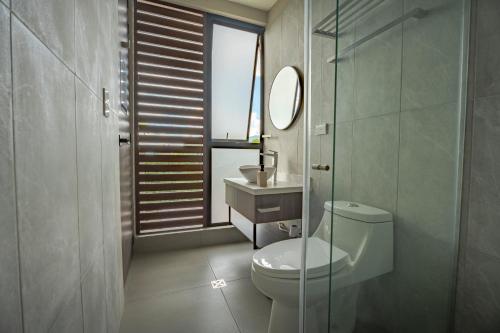 a bathroom with a toilet and a sink and a mirror at Stella club & resort in Hacienda La Cabaña