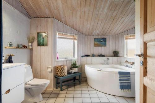 a bathroom with a white tub and a toilet at LN1951-Hirtshals-Klitrenden-1 in Hirtshals