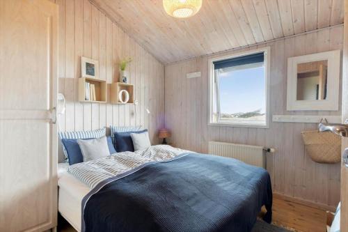 a bedroom with a bed in a room with a window at LN1951-Hirtshals-Klitrenden-1 in Hirtshals
