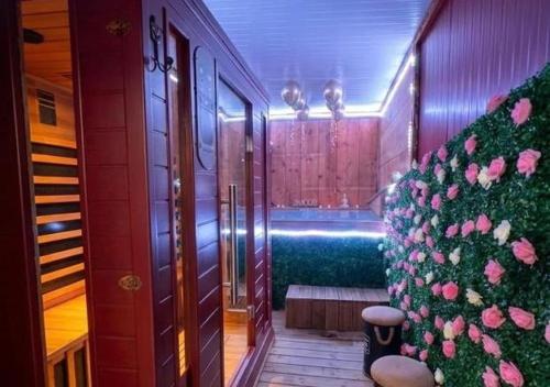 a hallway with a plant with pink flowers on it at Doux Pavillon - Sauna - Jacuzzi in Tassin-la-Demi-Lune
