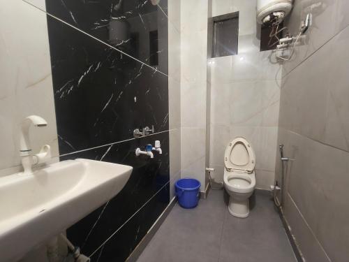 a small bathroom with a toilet and a sink at Hotel Gareen By Du Rooms Near Delhi University Kamlangar in New Delhi