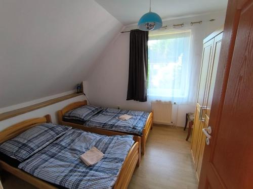 two beds in a small room with a window at Vila v Podkrušnohoří in Jirkov