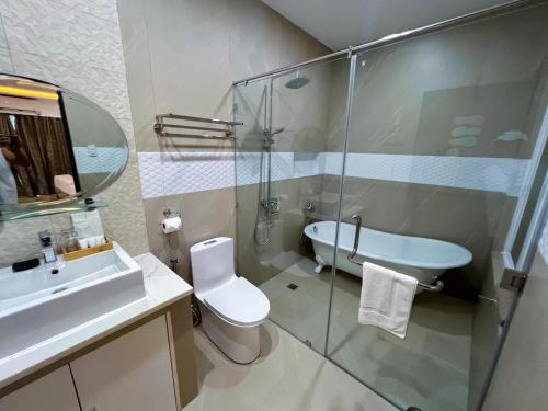 a bathroom with a sink and a toilet and a glass shower at Yuhum Boracay Suites in Boracay