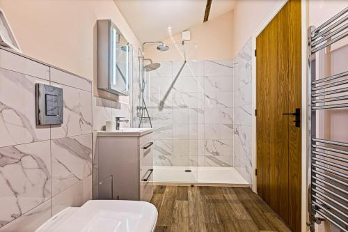 a bathroom with a shower and a toilet and a sink at Shippon 1 in Radley