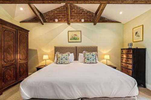 a bedroom with a large white bed with two pillows at Shippon 1 in Radley