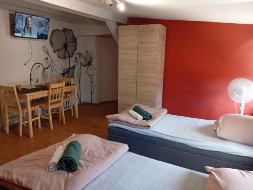 a room with two beds and a dining room at Apartament Rynek 30 in Osieczna