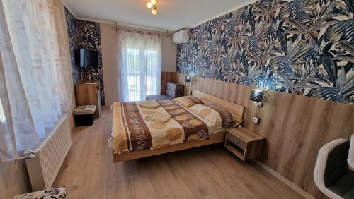 a bedroom with a bed and a wall mural at Napsugár Resort in Siófok