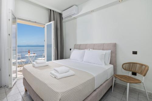 a bedroom with a bed and a view of the ocean at Aeloria Boutique Hotel Corfu in Benitses