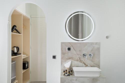 a white bathroom with a sink and a mirror at Aeloria Boutique Hotel Corfu in Benitses