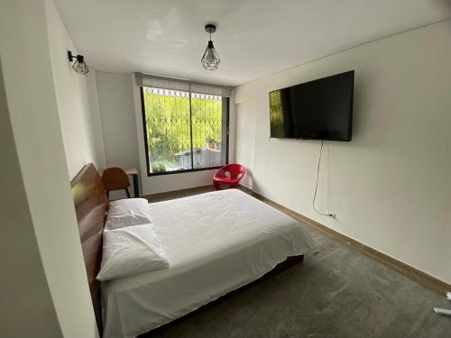a bedroom with a bed and a flat screen tv at Textileria in Pereira