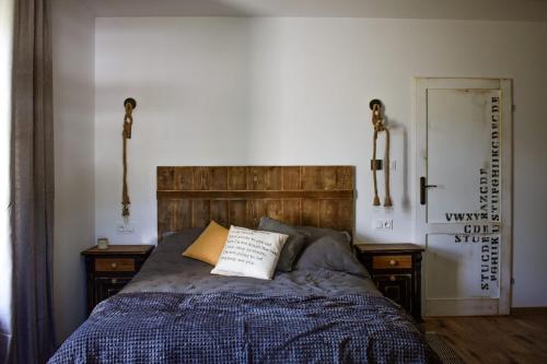 a bed with a wooden headboard and two night stands at Apartament Antracytowe Wrota 3 in Boguszów-Gorce