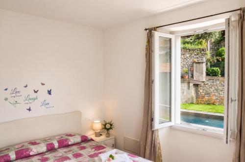 a bedroom with a bed and a window at Lescen White Residence - Lake View in Lezzeno