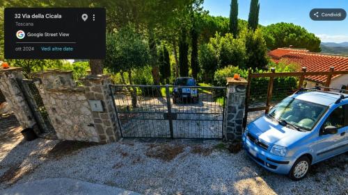 a blue car parked in front of a gate at Affittacamere Del Geco - Elba Affitti in Procchio