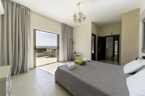 a bedroom with a large bed and a balcony at Villa Caterina in Skala